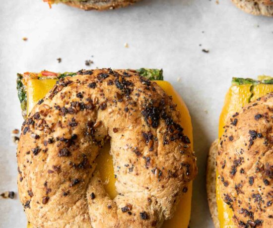 Close up of Meal Prep Breakfast Egg Bagel sandwiches on a baking sheet.