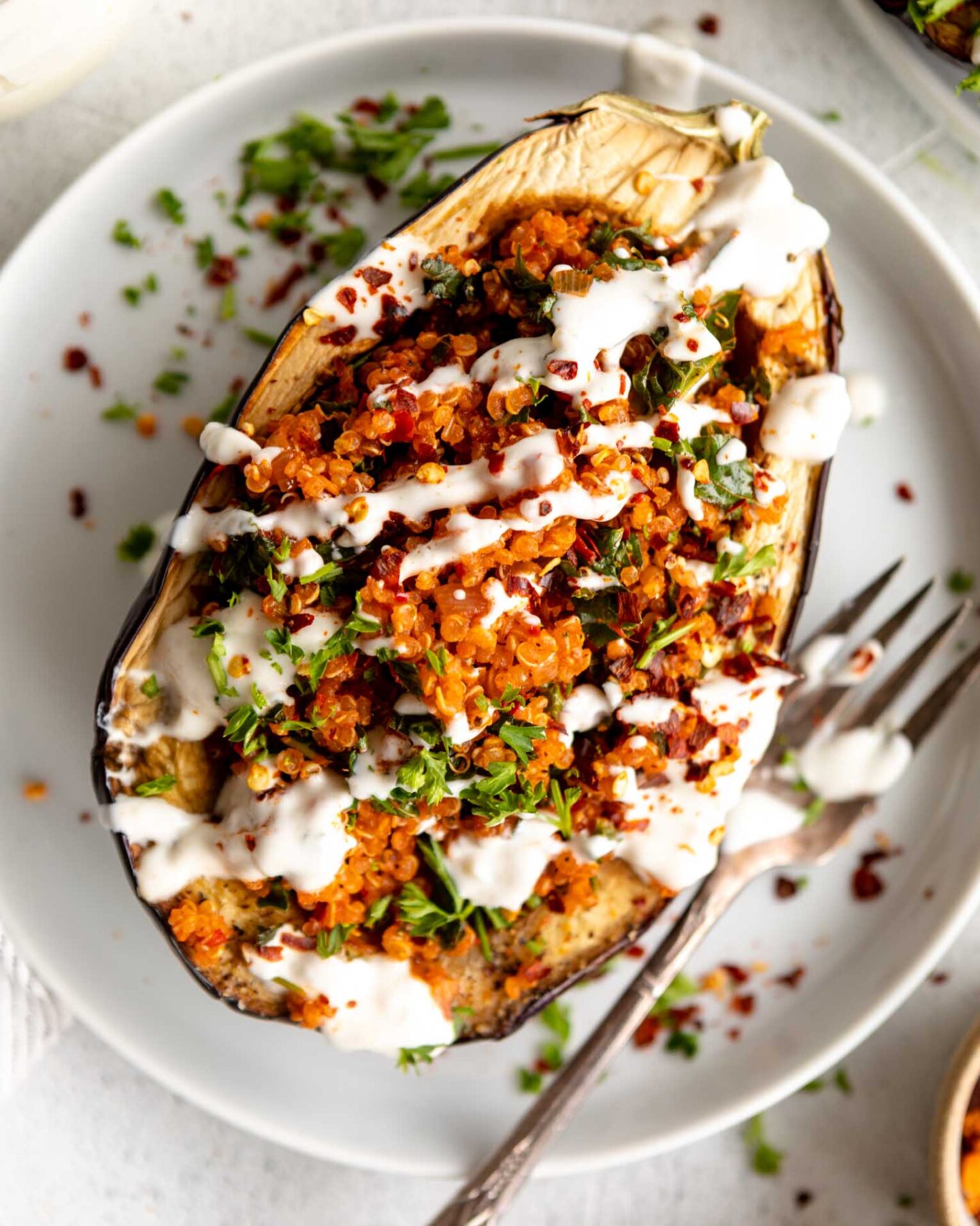 Roasted Harissa Stuffed Eggplant on a plate with yogurt drizzle.