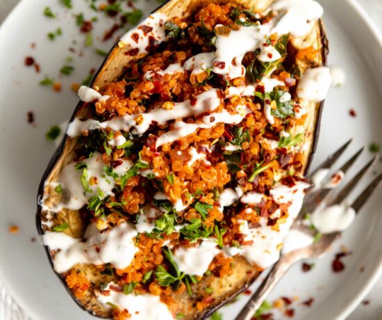 Roasted Harissa Stuffed Eggplant on a plate with yogurt drizzle.