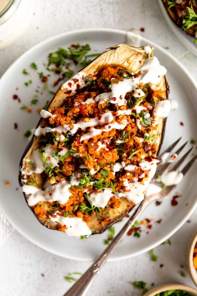 Roasted Harissa Stuffed Eggplant on a plate with yogurt drizzle.