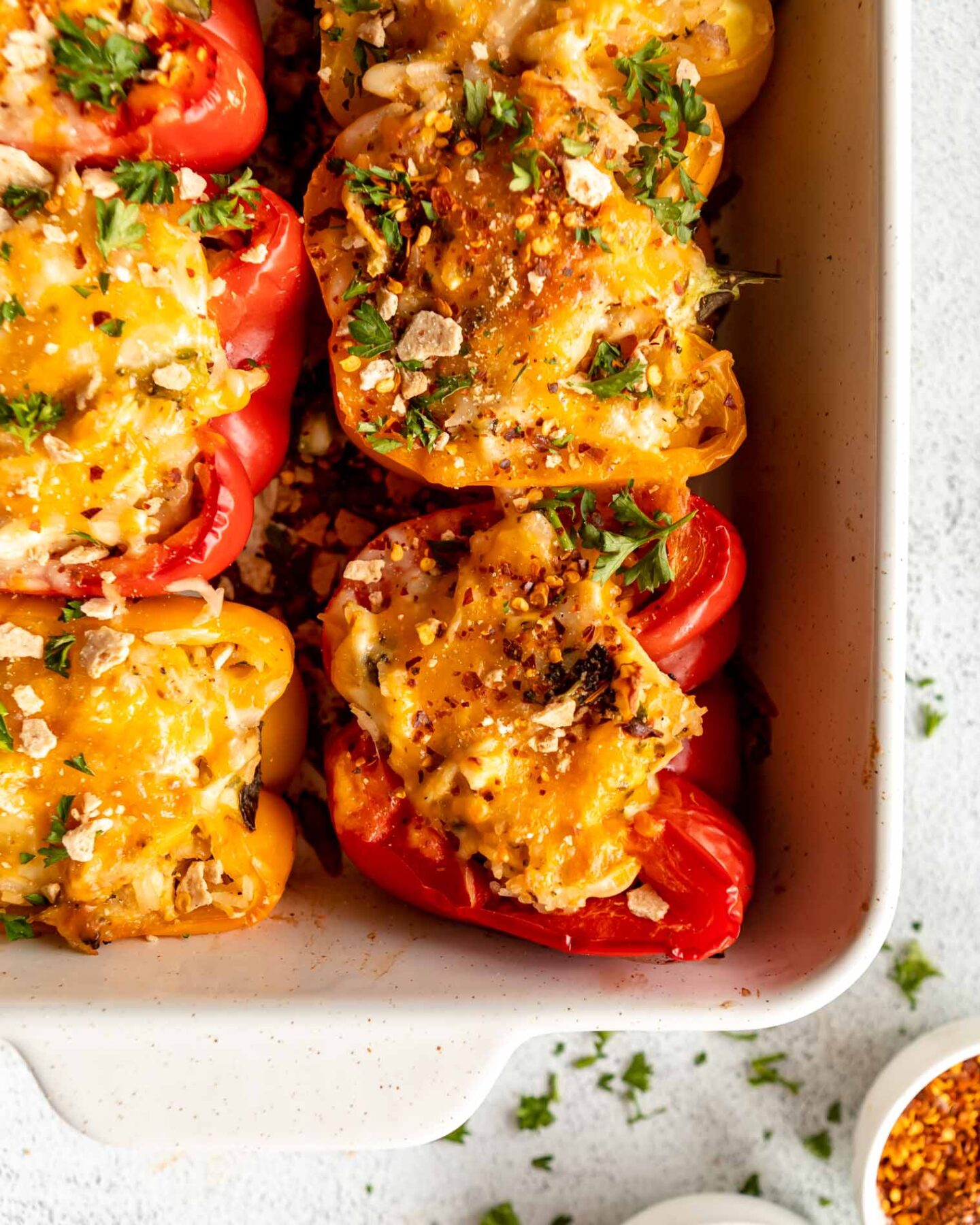 Shredded chicken stuffed peppers in a baking dish.