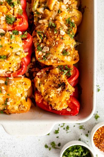Shredded chicken stuffed peppers in a baking dish.