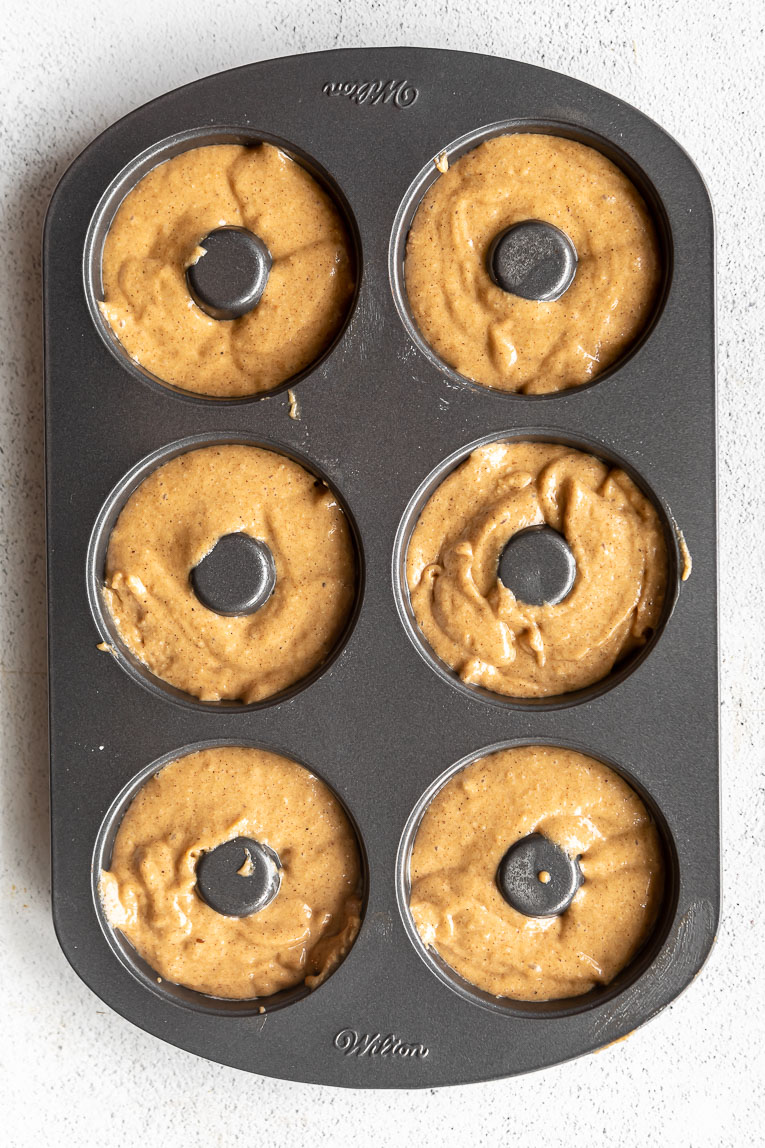 Donut batter poured into a donut pan.