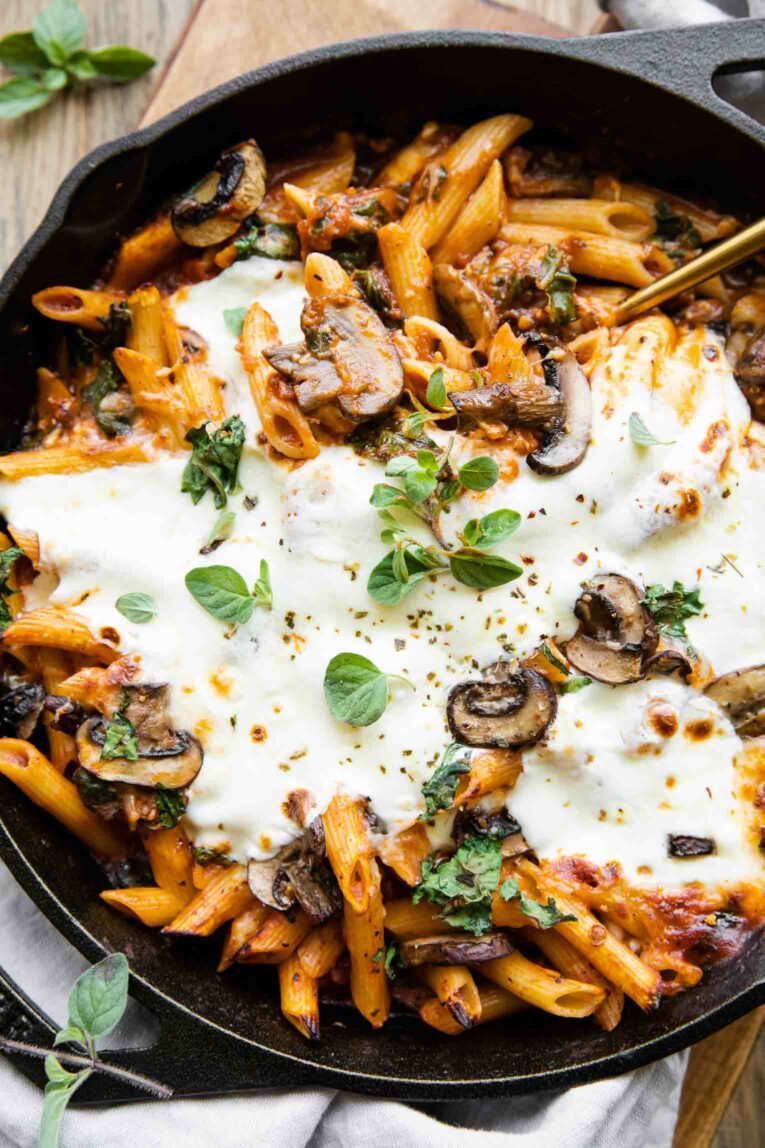 Mushroom and spinach with pasta baked in a cast iron skillet.