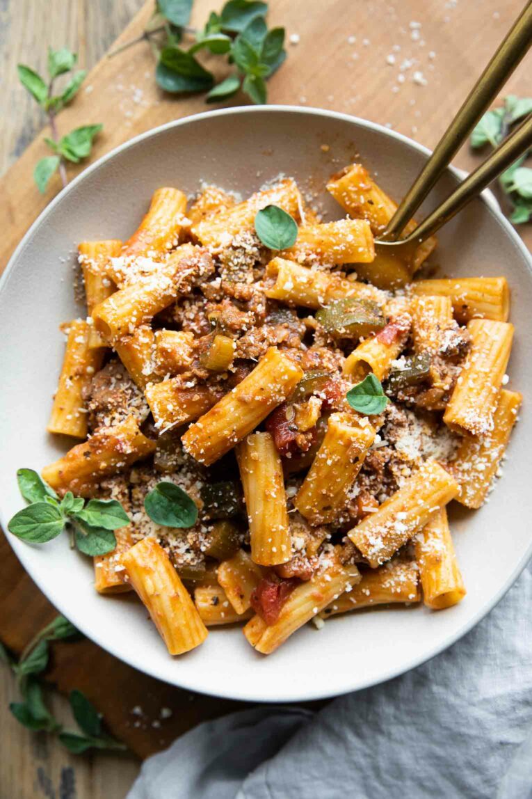 Rigatoni Bolognese recipe with fresh oregano on a plate.