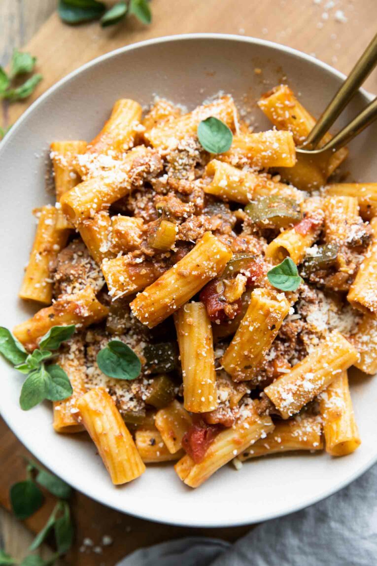 One-Pot Rigatoni Bolognese in a white bowl with forks.