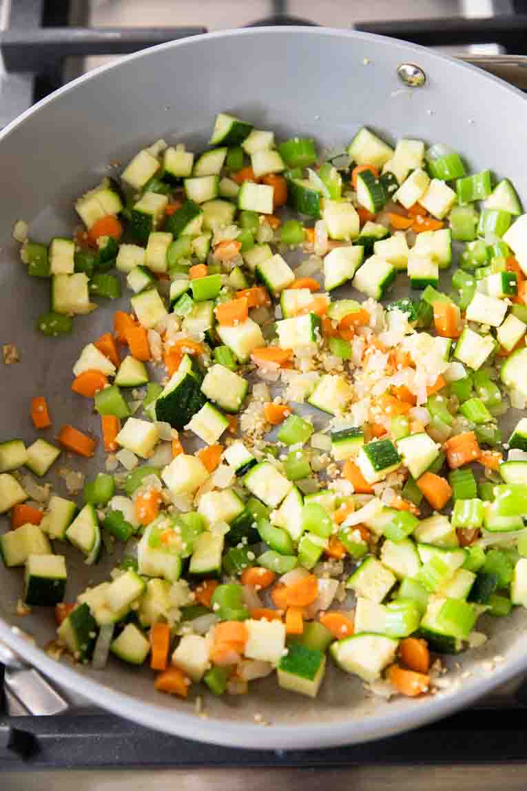 Vegetables being sautéed in a pan.