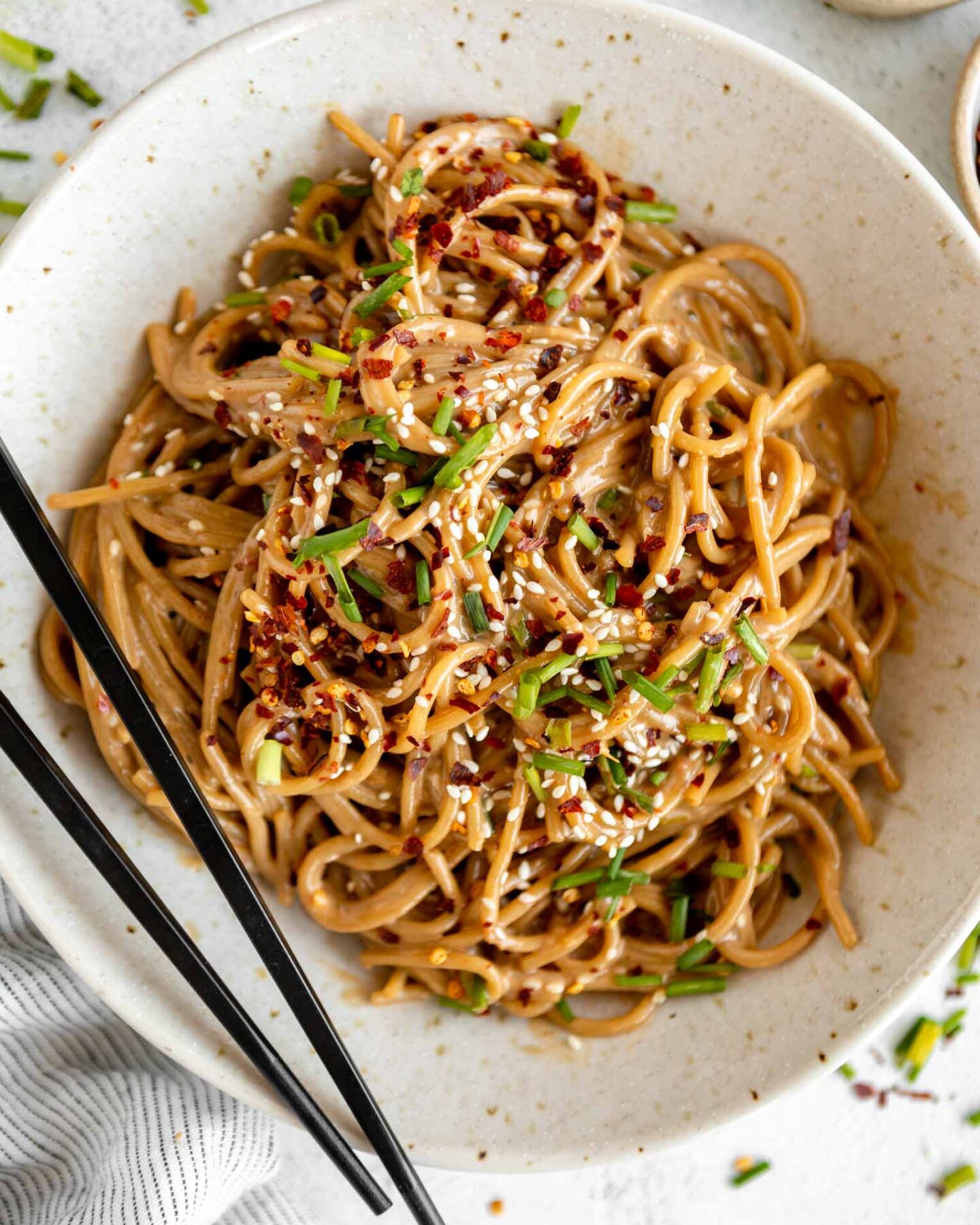 Sesame Tahini Noodles recipe in a bowl with chopsticks.