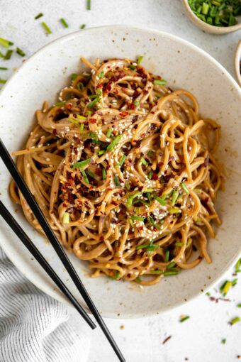 Sesame Tahini Noodles recipe in a bowl with chopsticks.