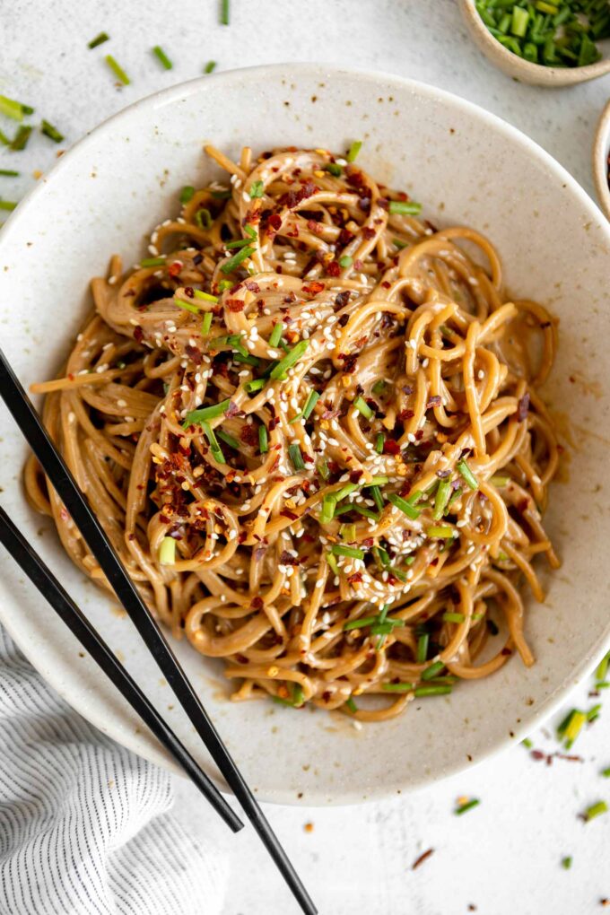 Sesame Tahini Noodles recipe in a bowl with chopsticks.