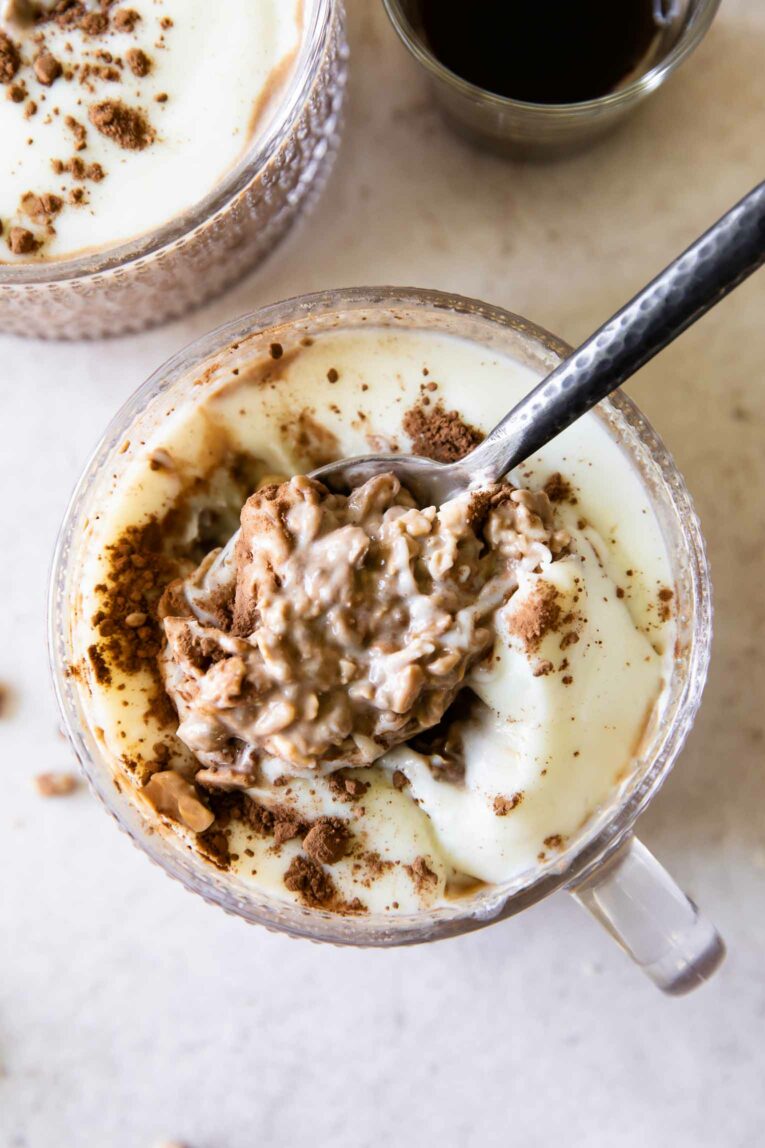 Spoonful of Tiramisu Overnight Oats with creamy yogurt topping.