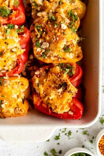 Shredded chicken stuffed peppers in a baking dish.