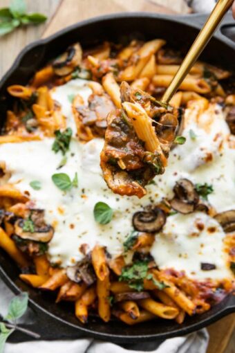 Cheesy spoonful of Mushroom & Spinach Pasta Bake being taken out of dish.