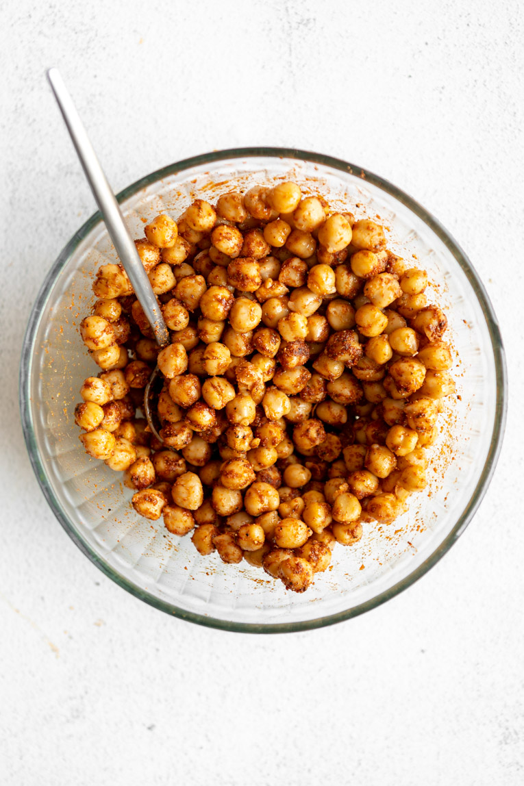 Chickpeas tossed in seasoning in a bowl.