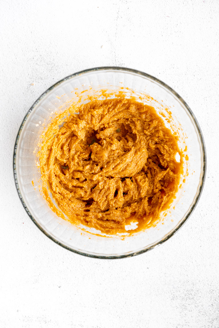 Liquid ingredients mixed in a mixing bowl for pumpkin cookies.