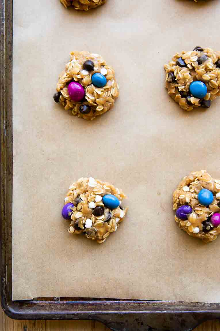 Gluten-Free Monster Cookie dough scooped on a baking sheet.
