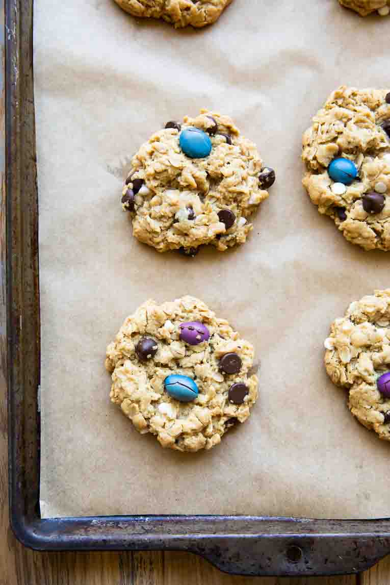 Freshly baked Gluten-Free Monster Cookies on a baking sheet.