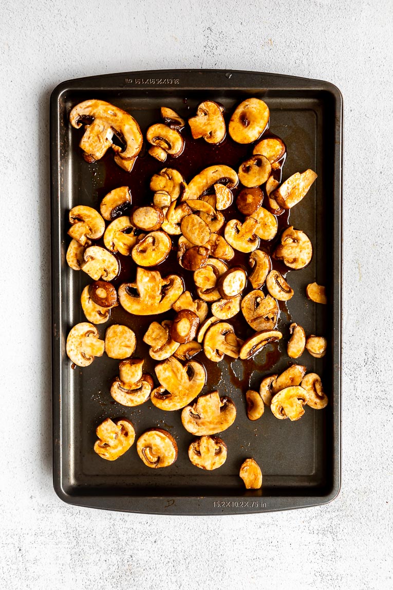Mushrooms being roasted on a sheet pan.
