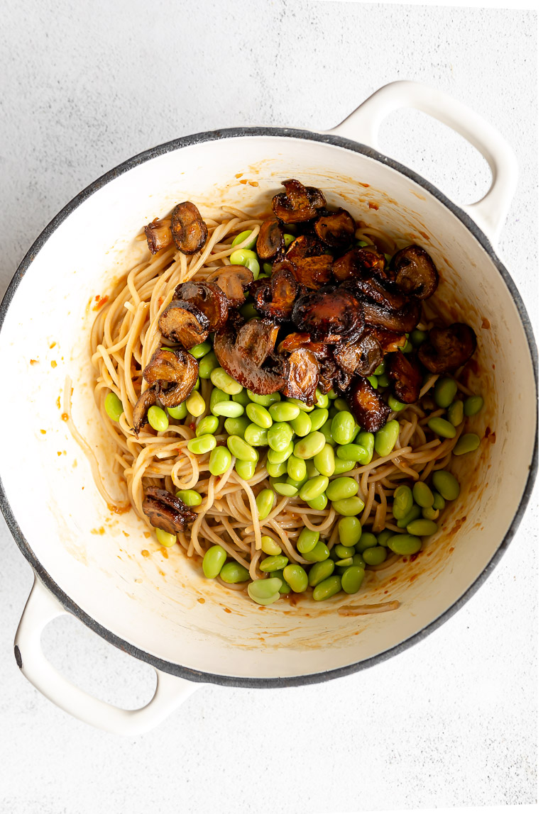 Miso noodles with mushrooms and edamame being cooked.