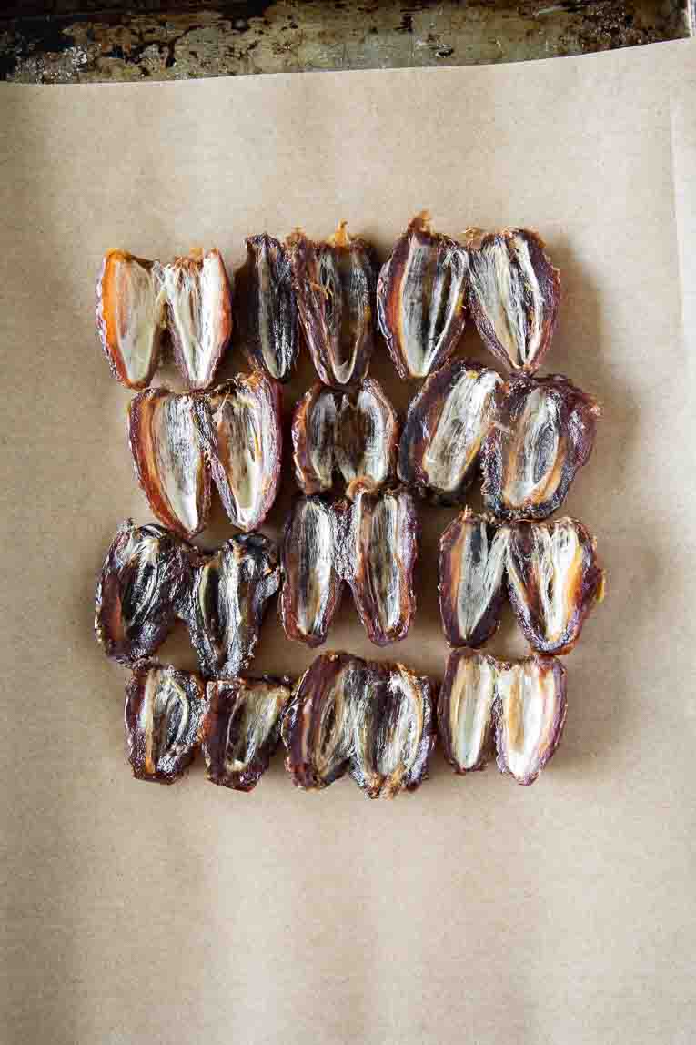 Dates opened and pitted on a baking sheet.