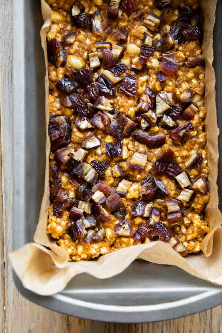 Pumpkin crunch mixture in a loaf pan with dates on top.