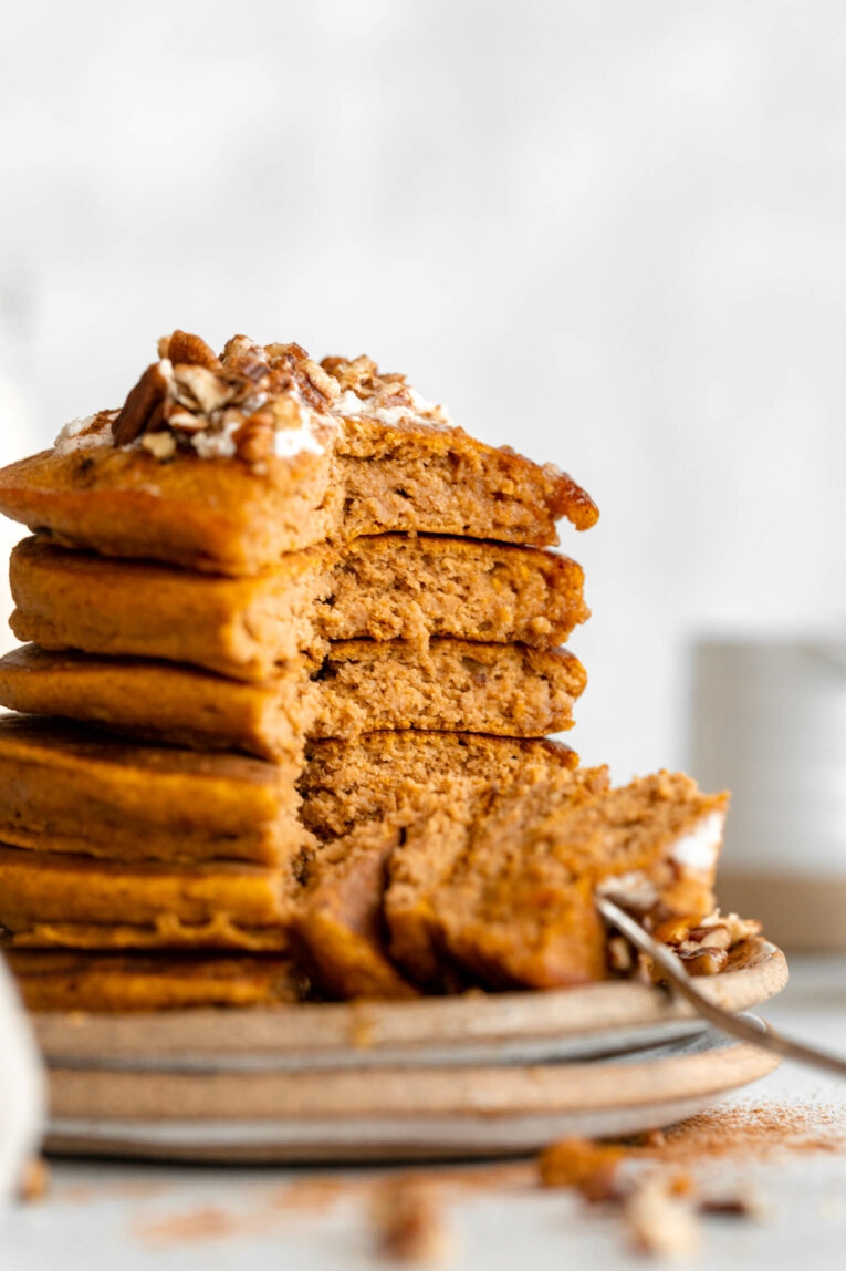 Stack of Pumpkin Oatmeal Pancakes with bite taken out.