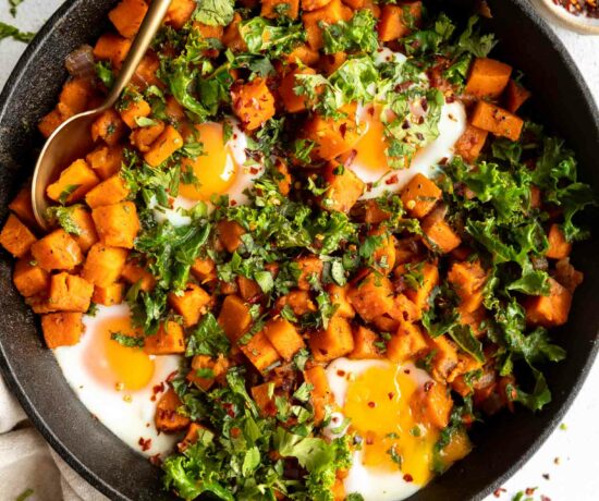 Skillet Sweet Potato Kale Hash recipe in a cast iron skillet with eggs.