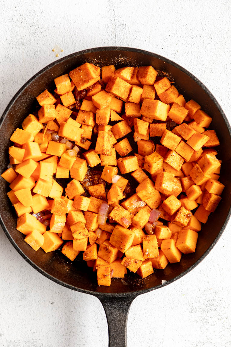 Sweet potatoes being sautéed in a skillet.