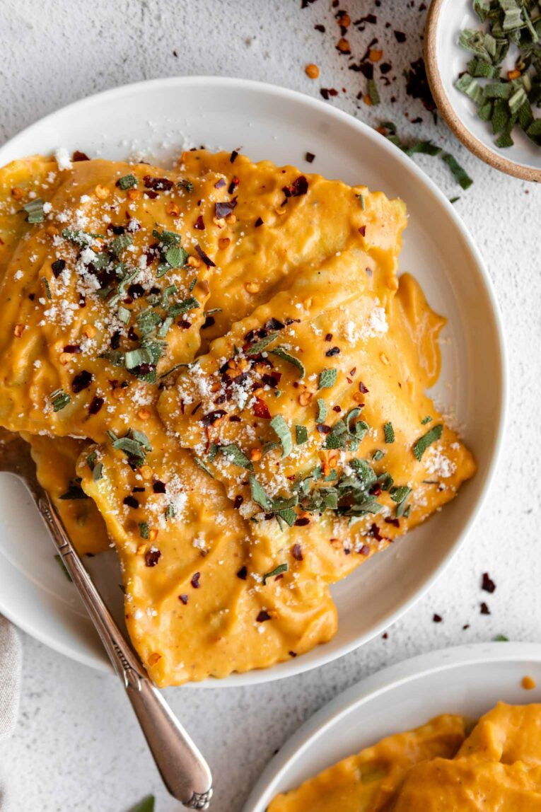 Top shot photo of cheese ravioli in a butternut squash sauce with sage and thyme.