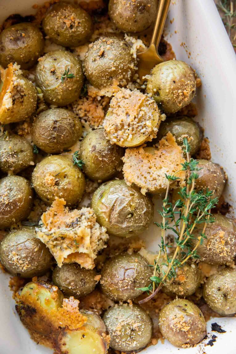 Small gold potatoes in a casserole dish baked with garlic, parmesan, and thyme.