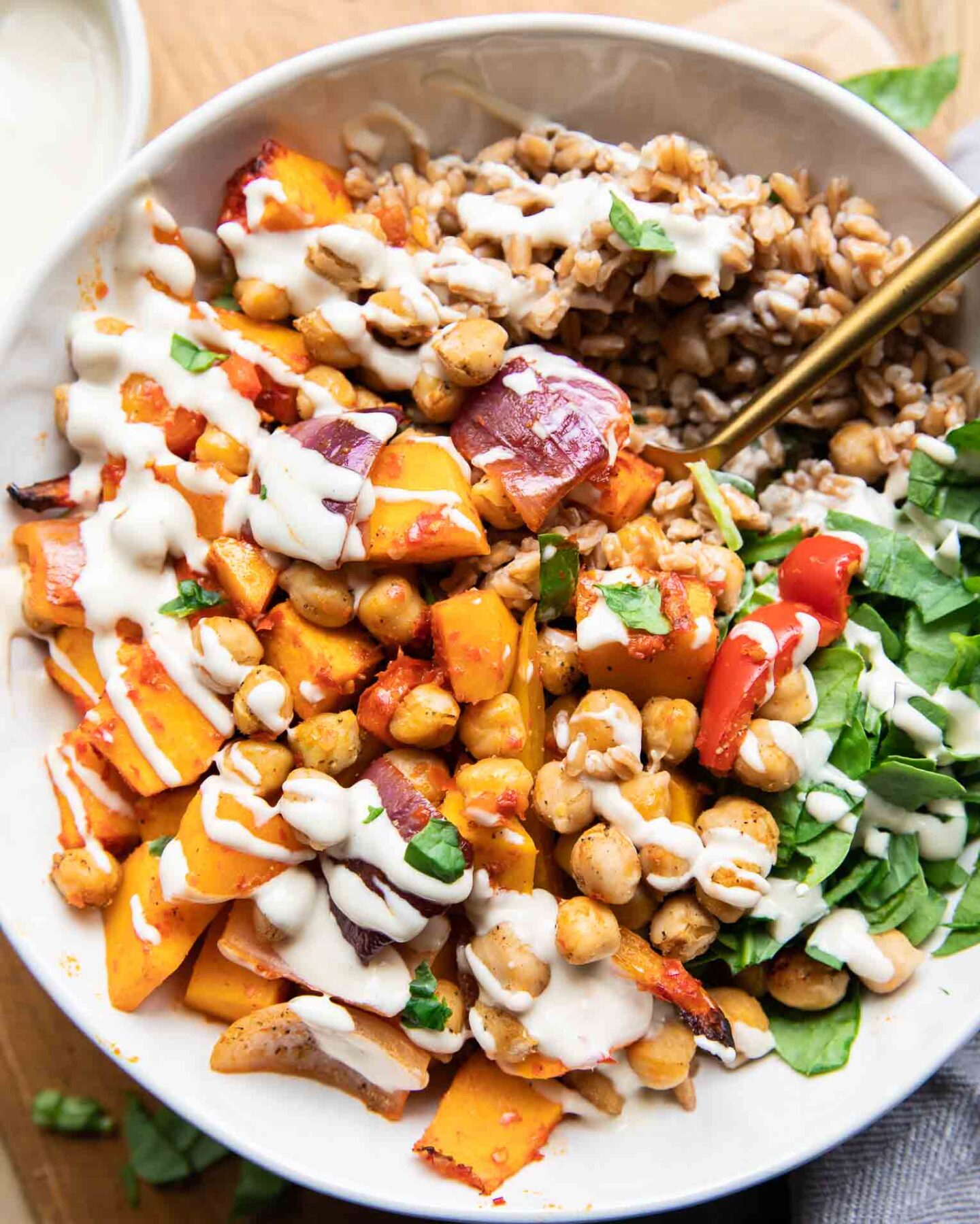Harissa Veggie Bowls recipe with a fork and tahini drizzle!