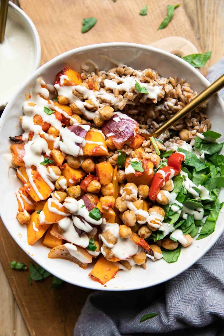Harissa Veggie Bowls with roasted vegetables, grains, and tahini sauce.