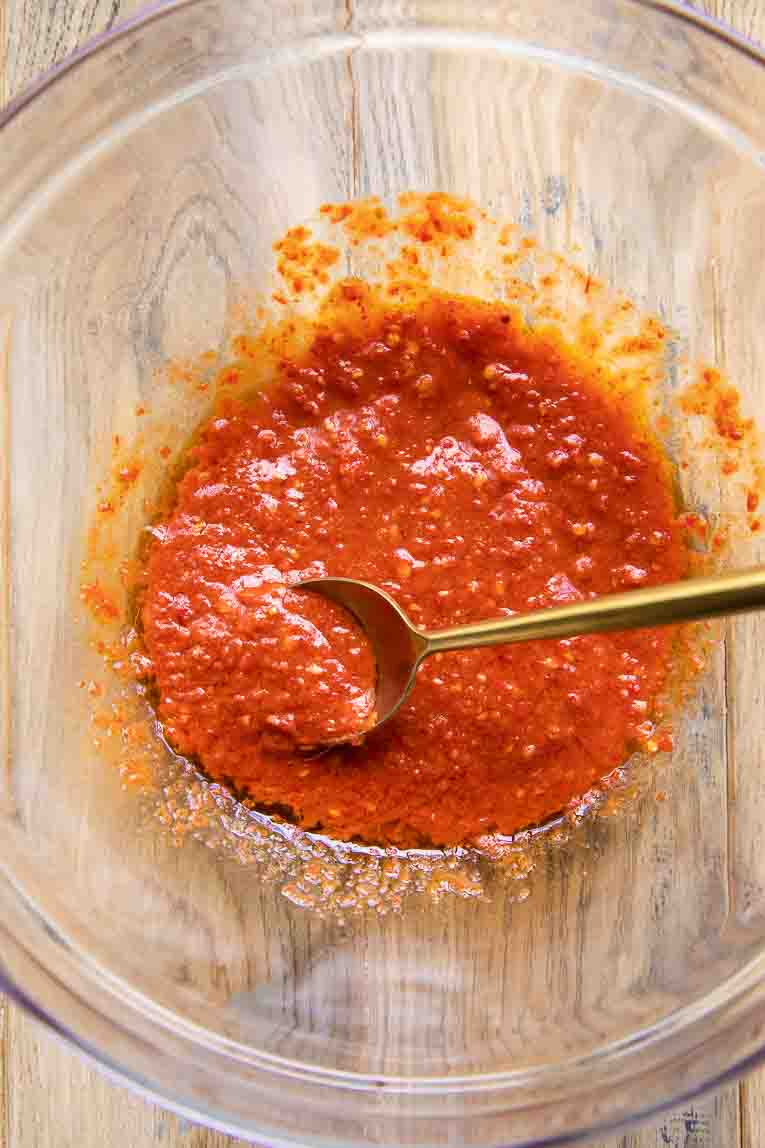Harissa paste sauce being mixed in a bowl.
