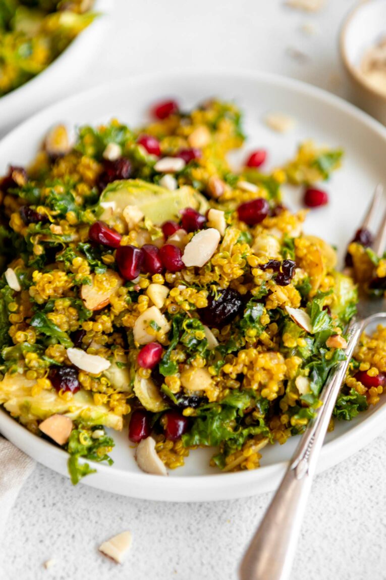 Angled photo of Kale & Brussels Sprouts Curry Quinoa Salad on a plate.