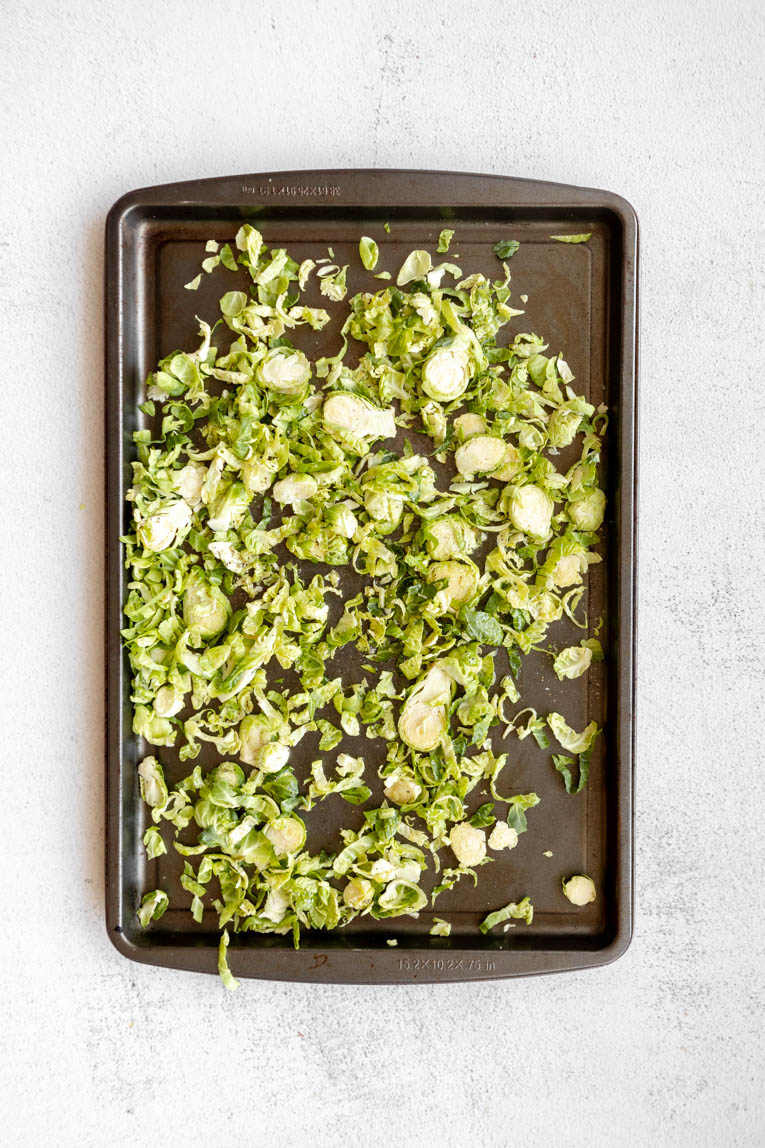 Brussels sprouts with oil and salt/pepper on a baking sheet.