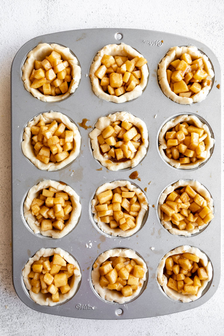 Mini gluten-free apple pies in a muffin tin.