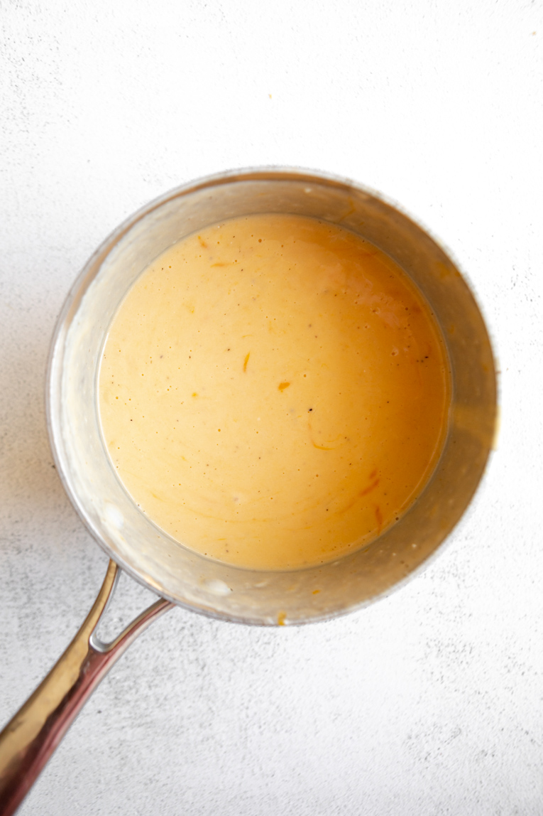 Milk and seasoning added to melted butter in a saucepan.