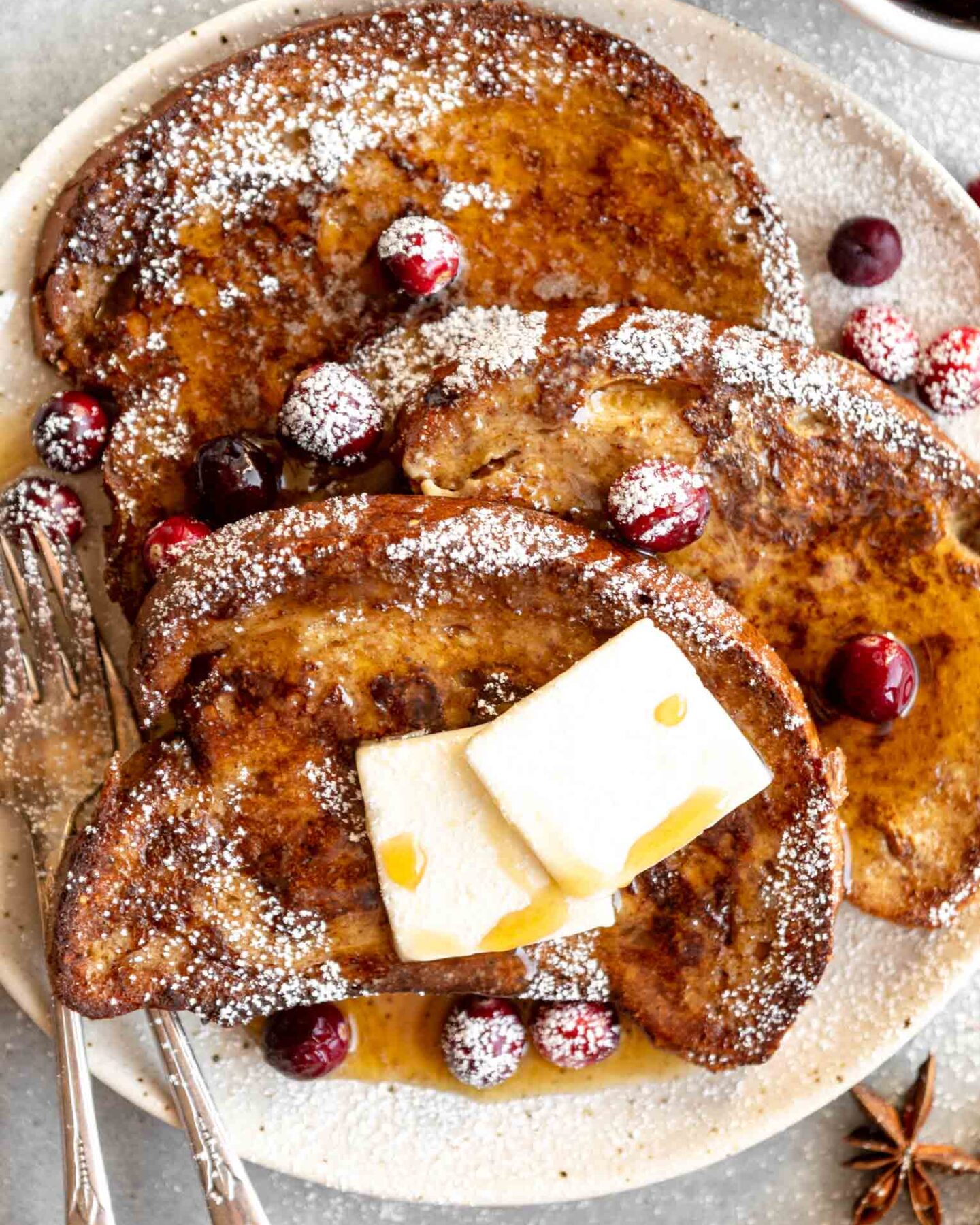Close up of Gingerbread French Toast with powdered sugar and cranberries.