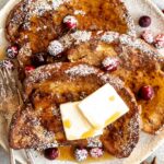 Close up of Gingerbread French Toast with powdered sugar and cranberries.