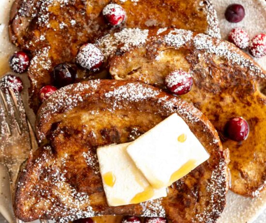 Close up of Gingerbread French Toast with powdered sugar and cranberries.