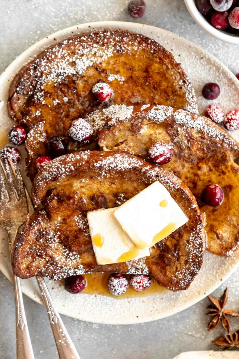 Close up of Gingerbread French Toast with powdered sugar and cranberries.