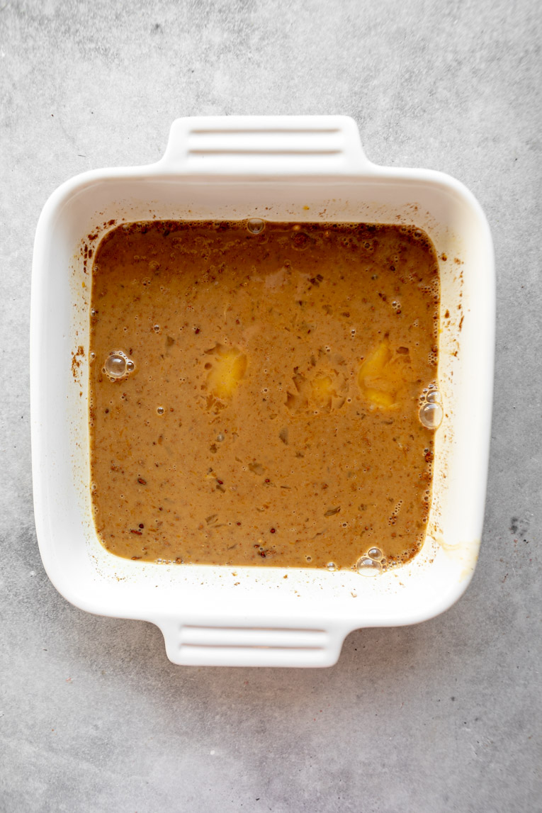 Gingerbread egg soak mixture in a baking dish.