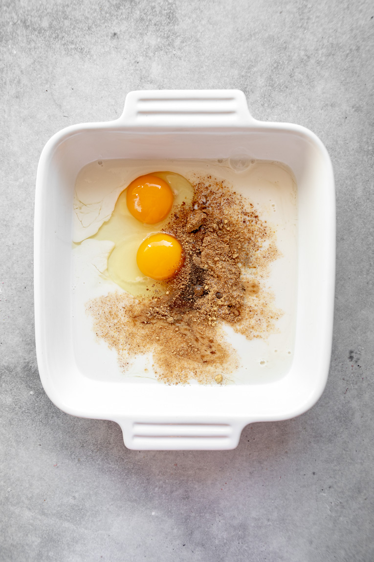 Eggs, milk, syrup, molasses, and gingerbread spices in a baking dish.