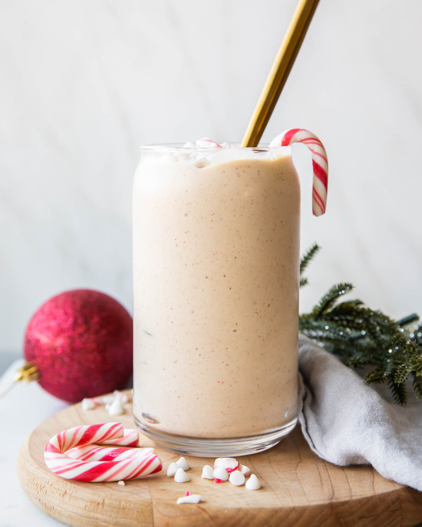 Peppermint Frosty Recipe in a glass with candy canes.