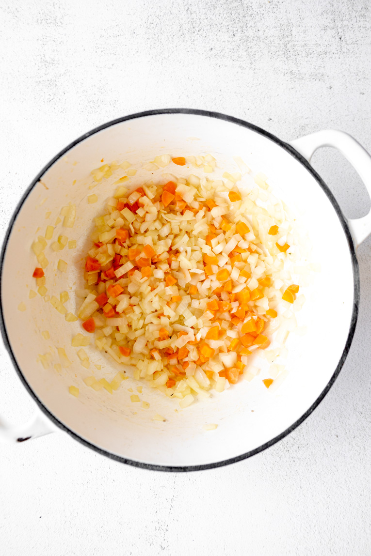 Carrots and onions diced and sautéed in a dutch oven.