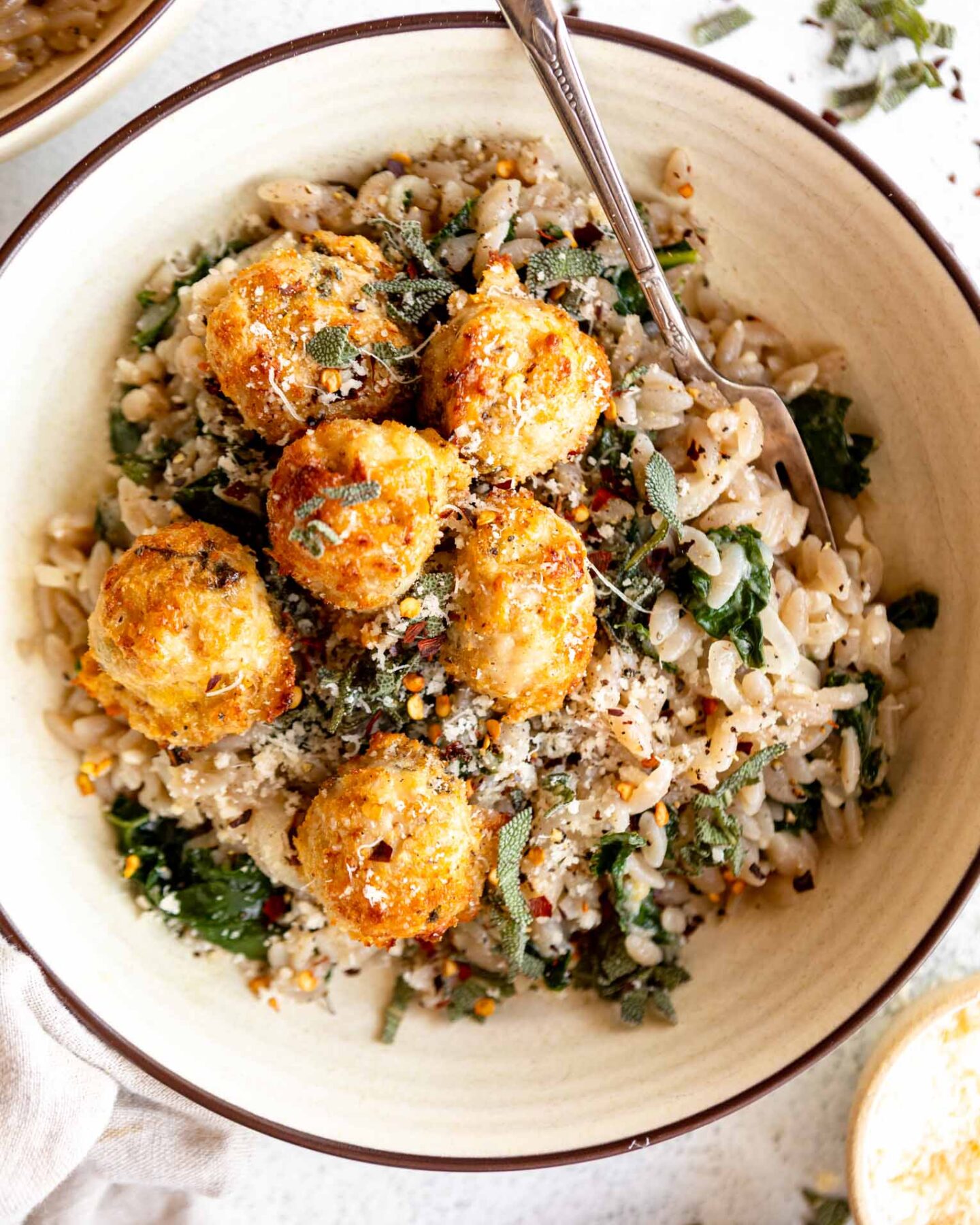 Turkey Sage Meatballs in a dutch oven with parmesan kale orzo.