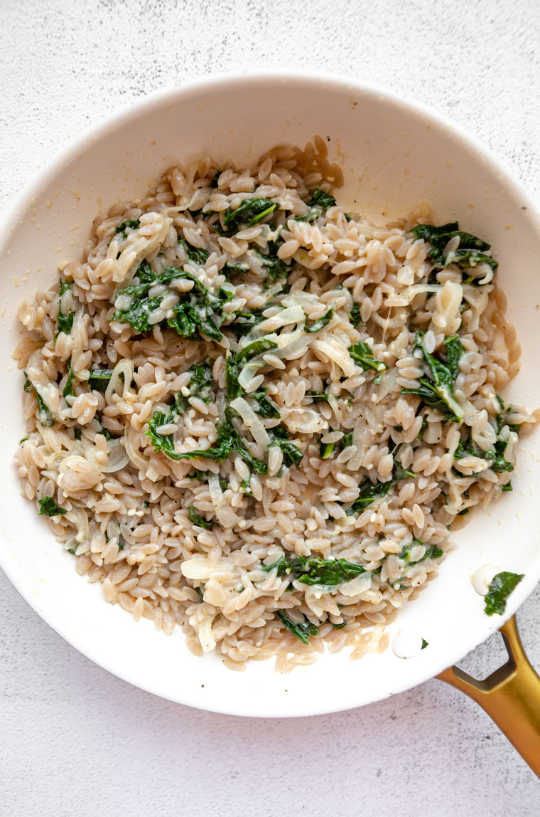 Kale parmesan orzo in a skillet.