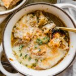Cozy bowl of Vegetarian French Onion Soup with bread and cheese on top.