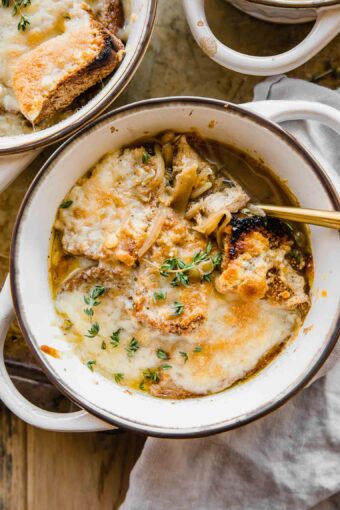 Cozy bowl of Vegetarian French Onion Soup with bread and cheese on top.