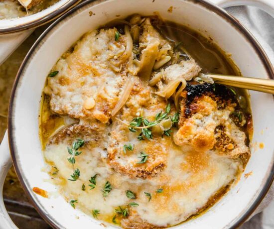 Cozy bowl of Vegetarian French Onion Soup with bread and cheese on top.